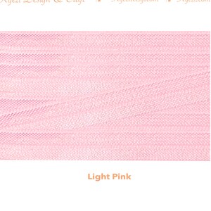 May include: Light pink tulle fabric with a fine, woven texture. The fabric is soft and delicate, and it has a slightly shimmery finish.