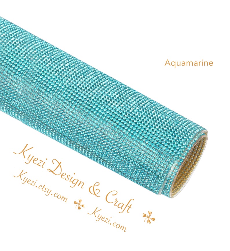 May include: A roll of aquamarine blue rhinestone sheet. The sheet is covered in small, sparkling rhinestones. The text "Kyezi Design & Craft" and "Kyezi.etsy.com" is visible on the bottom left corner of the image.