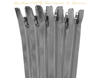 May include: A close-up of a bundle of eight grey zipper closures. The zippers are all closed and have a metal tooth design.