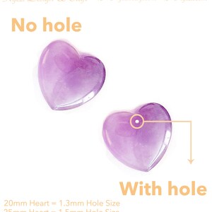 K&ouml;nnte beinhalten: Zwei durchscheinende, herzf&ouml;rmige Perlen in Lila, eine mit und eine ohne Loch. Der Text "No hole" steht &uuml;ber dem ersten Herz, und "With hole" unter dem zweiten. Der Text gibt die Lochgr&ouml;&szlig;e f&uuml;r 20 mm und 25 mm Herzen an.