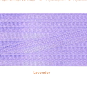 May include: A close-up of a lavender-colored tulle fabric. The fabric has a fine, delicate texture and a soft, flowing drape.