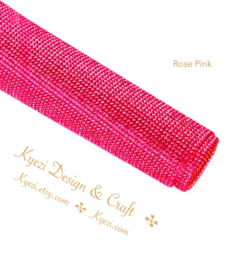 May include: A roll of rose pink rhinestone mesh fabric. The fabric is made of small, sparkling rhinestones that are sewn together in a grid pattern. The fabric is perfect for adding a touch of glamour to any project.