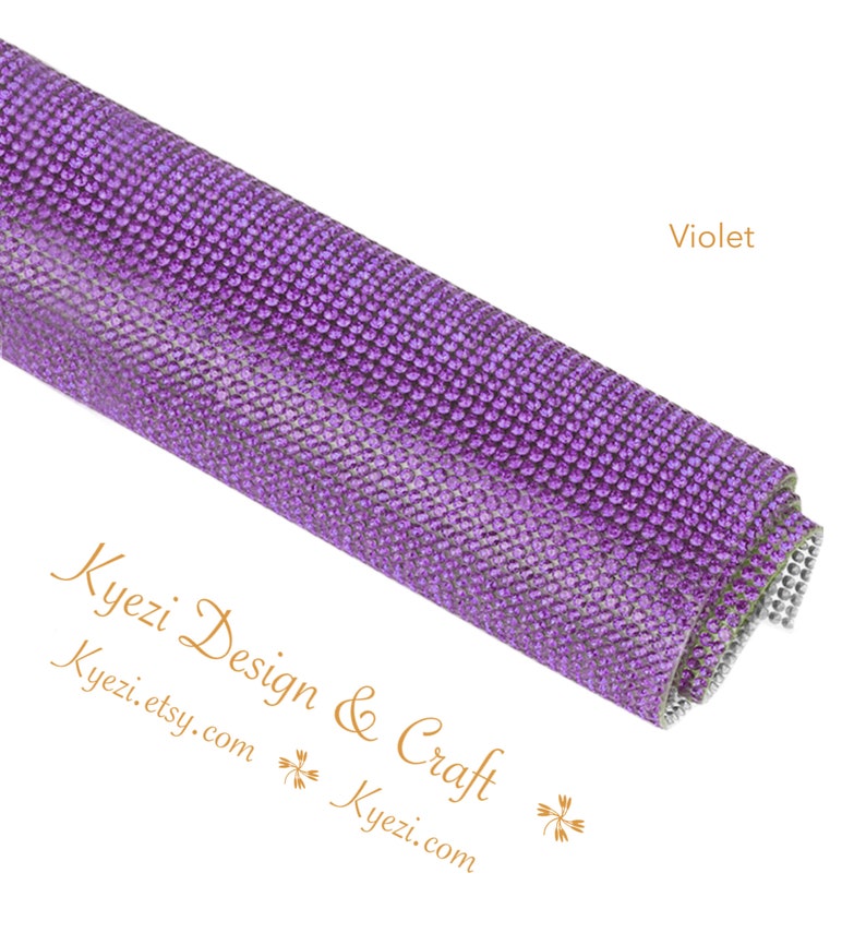 May include: A roll of purple rhinestone mesh fabric. The fabric is covered in small, round rhinestones. The fabric is rolled up and the end of the roll is visible. The text "Violet" is visible in the upper right corner of the image.