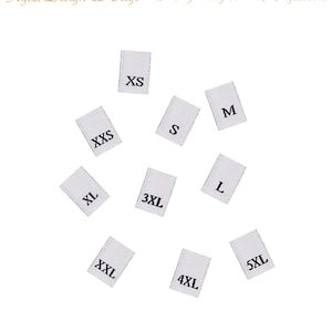 Puede incluir: Etiquetas de talla de ropa de tela blanca con texto negro. Las etiquetas incluyen las tallas XS, XXS, XL, 3XL, XXL, 4XL, 5XL, S, M y L.