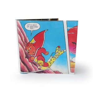 May include: A bi-fold wallet featuring a comic book illustration. The artwork depicts a bear in a red superhero costume running alongside a yellow character with a jetpack. Text in a speech bubble reads, "LET'S SPLIT UP AND FIND TEX!"