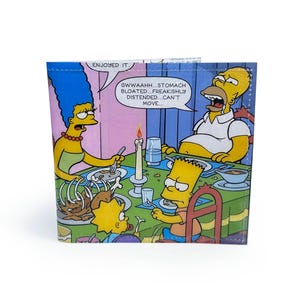May include: A bi-fold wallet featuring a scene from The Simpsons cartoon. The image shows the family at a dinner table with speech bubbles. The text in the speech bubble says "GWWAAHH...STOMACH BLOATED...FREAKISHLY DISTENDED...CAN'T MOVE..."