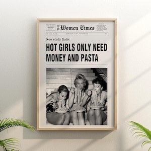 以下が含まれることがあります： The Women Timesというタイトルのヴィンテージ風新聞の表紙が描かれた額入りウォールアートプリント。見出しには「New study finds: HOT GIRLS ONLY NEED MONEY AND PASTA」と書かれています。下部には、パスタを食べている3人が写った白黒写真があります。