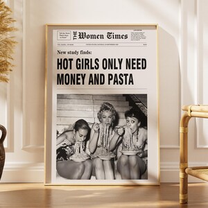 以下が含まれることがあります： The Women Timesというタイトルの白黒新聞レイアウトが印刷された額入りポスター。見出しには「New study finds: HOT GIRLS ONLY NEED MONEY AND PASTA」と書かれています。その下には、パスタを食べている3人が写った白黒写真があります。