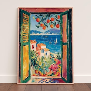 以下が含まれることがあります： 額縁に入った絵画で、開いた窓から見える活気のある海岸の風景を描いています。鮮やかな青い海、赤い屋根の白い建物、木から吊り下げられたオレンジが特徴です。窓枠は緑と黄色です。