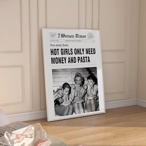 以下が含まれることがあります： The Women Timesというタイトルの白黒新聞デザインが施された額入りポスター。見出しには「New study finds: HOT GIRLS ONLY NEED MONEY AND PASTA」と書かれています。テキストの下には、パスタを食べている3人の白黒写真があります。