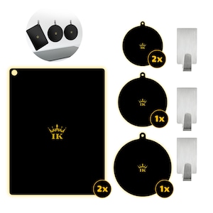 Op de afbeelding: Een set zwarte keukenaccessoires bestaande uit één rechthoekige mat en drie ronde matten, elk voorzien van een gouden kroonlogo met de letters IK. De set bevat drie zilverkleurige metalen haken voor het ophangen van de matten met gaten.