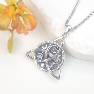 May include: A silver-toned pendant necklace featuring a triquetra shape with engraved text including "Speak with love," "Honor your word," "Be kind," "Blessed be," "Know your power," "Listen with love," "Mind boundaries," and "See only with love."