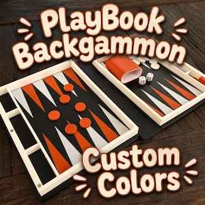 May include: A PlayBook Backgammon set featuring a black board with orange and white triangular points, orange playing checkers, a matching orange dice cup, and two white dice. The text PlayBook Backgammon and Custom Colors is visible.