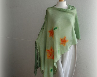 Op de afbeelding: Een groene sjaal met oranje en gele bloemmotieven. De sjaal is over een mannequin gedrapeerd en heeft een gefranst randje.