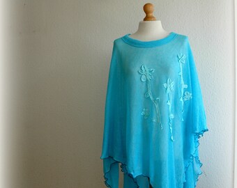 May include: A light blue poncho with white embroidered flowers and a scalloped hem.