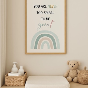 May include: A framed print with the text "YOU ARE NEVER TOO SMALL TO BE great" above a pastel rainbow illustration. A wicker basket with white bottles and a changing mat sit on a wooden chest of drawers, with a teddy bear and a woven basket.