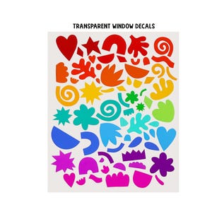 May include: A sheet of transparent window decals featuring a variety of abstract shapes including hearts, stars, swirls, and organic forms arranged in a rainbow color gradient from red at the top to pink at the bottom, with the text TRANSPARENT WINDOW DECALS.