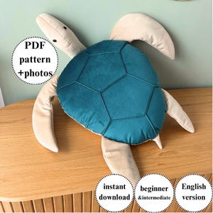 Op de afbeelding: Een schildpadvormig kussen met een turquoise schild en crèmekleurige vinnen en kop. De schild heeft een geometrisch patroon. De afbeelding bevat tekst met de tekst "PDF pattern + photos", "instant download", "beginner & intermediate" en "English version".