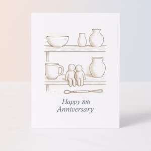 Peut inclure: Carte de vœux avec une illustration dessinée à la main. L'image présente deux étagères avec des poteries, une tasse et deux personnages. Le texte "Happy 8th Anniversary" est écrit en bleu foncé en dessous.