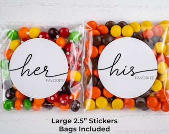 Peut inclure: Deux sacs en cellophane transparents remplis de bonbons colorés. Chaque sac porte un autocollant circulaire blanc avec les mots "her favorite" et "his favorite" en écriture noire. Les bonbons sont de couleurs variées.
