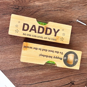 May include: Two bamboo bottle openers with level vials. One opener says "DADDY" with "NO ONE CAN LEVEL UP TO YOU!" below. The other says "Happy birthday! To the best dad in the world."