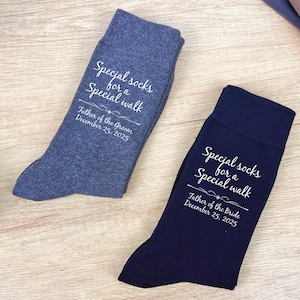 May include: Two pairs of socks, one blue and one navy, with the text "Special socks for a Special walk" and the date "December 25, 2025". The socks are personalized for the Father of the Groom and the Father of the Bride.