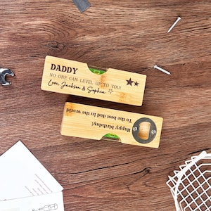 May include: Two bamboo bottle openers and levels with engraved text. One says "DADDY" and "NO ONE CAN LEVEL UP TO YOU! Love, Jackson & Sophia." The other says "Happy birthday! To the best dad in the world!"