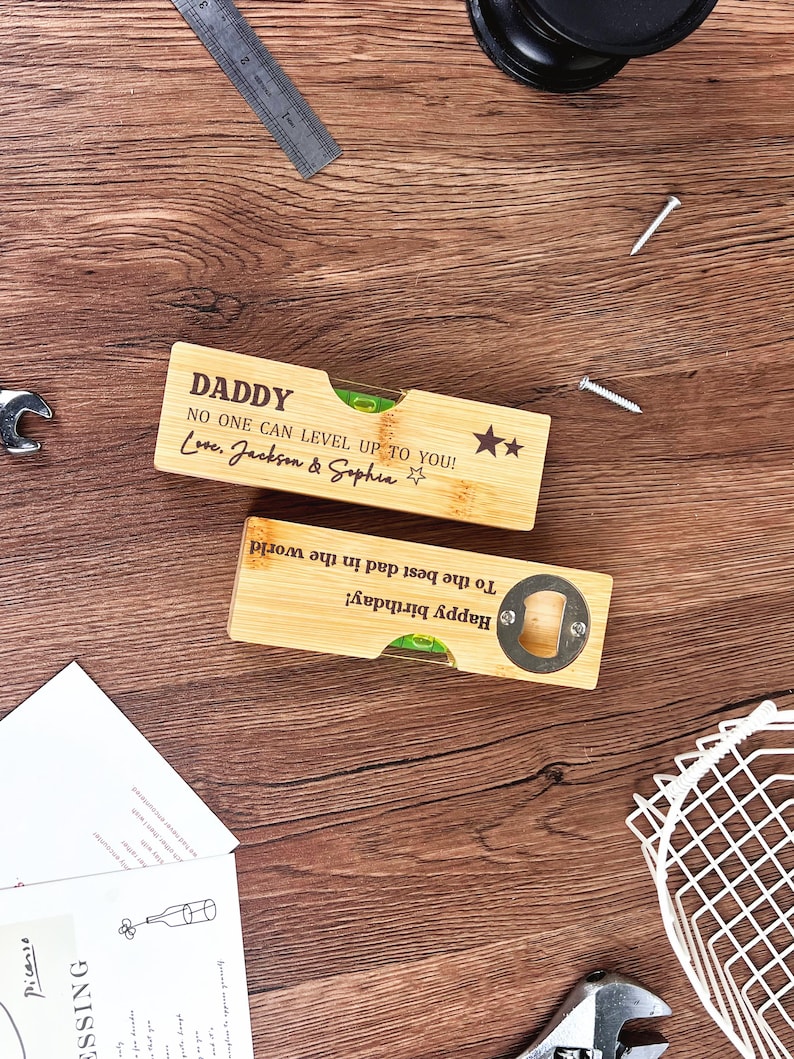 May include: Two bamboo bottle openers and levels with engraved text. One says "DADDY" and "NO ONE CAN LEVEL UP TO YOU! Love, Jackson & Sophia." The other says "Happy birthday! To the best dad in the world!"