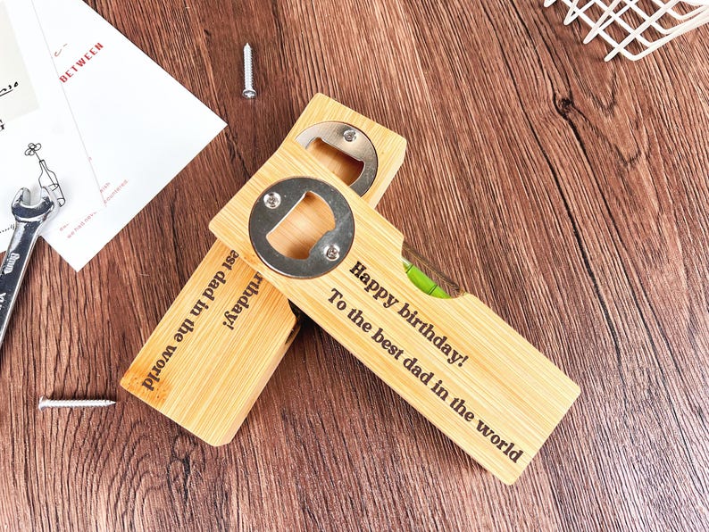 May include: Two wooden bottle openers with a built-in level and a metal bottle cap opener. One opener reads "Happy birthday! To the best dad in the world." The other reads "est dad in the world birthday!"