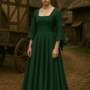 Könnte beinhalten: Eine Frau in einem langen, dunkelgrünen Kleid mit quadratischem Ausschnitt und ausgestellten Ärmeln. Das Kleid hat einen weiten Rock. Der Hintergrund zeigt rustikale Holzgebäude und einen Karren, was ein historisches oder mittelalterliches Thema suggeriert.
