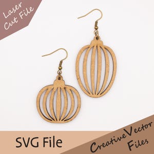 May include: A pair of wooden earrings with a light brown finish. Each earring features a decorative, openwork design with vertical lines, suspended from gold-colored ear wires. The image also includes the text "Laser Cut File" and "SVG File".