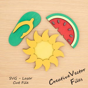 Op de afbeelding: Houten uitsparingen met zomerthema: een groene en gele slipper, een gele zon en een plak watermeloen. De watermeloen is rood met zwarte zaden en een groene schil. De tekst "SVG - Laser Cut File" en "Creative Vector Files" zijn zichtbaar.
