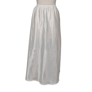 May include: A white, full-length slip with a gathered waist and a scalloped hem. The slip is made of a shiny, lightweight fabric, and is designed to be worn under a skirt or dress. The slip is a classic undergarment.