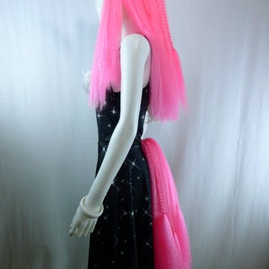 May include: A black dress with a white star pattern and a pink unicorn tail. The dress is sleeveless and has a fitted bodice. The unicorn tail is long and fluffy.