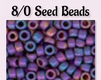 May include: A close-up image of 8/0 seed beads in a deep purple color with iridescent shimmer. The beads are small and round, and they are arranged in a random pattern.
