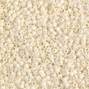May include: A close-up image of a large quantity of small, white, round seed beads. The beads are arranged in a random pattern and are all the same size.