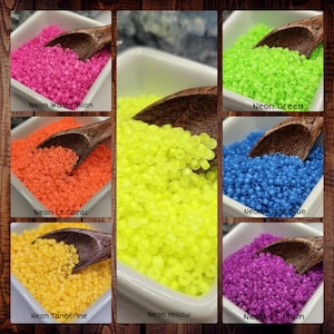 Puede incluir: Seis pequeños cuencos blancos, cada uno lleno de cuentas de semillas de color neón. Los cuencos están dispuestos en dos filas de tres. Las cuentas son de los siguientes colores: sandía neón, verde neón, coral claro neón, amarillo neón, mandarina neón y ciruela claro neón.