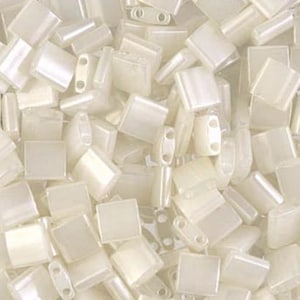 May include: A close-up shot of a pile of ivory-colored, rectangular beads. The beads have a slightly iridescent sheen and are of various sizes and shapes, including some with two holes. These beads are suitable for jewelry making and crafting.
