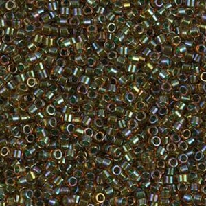 Può includere: Primo piano di un mucchio di piccole perline cilindriche. Le perline presentano un mix di colori oro, bronzo e iridescenti, con una lucentezza metallica. Sono sparse, creando una superficie strutturata, ideale per la creazione di gioielli o l'artigianato.
