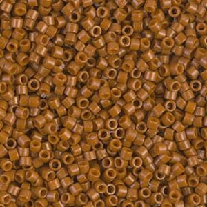 May include: Close-up of a pile of small, cylindrical, brown beads. Each bead has a hole running through the center. The beads are scattered, filling the frame, and appear to be made of plastic or a similar material. The color is a warm, earthy brown.