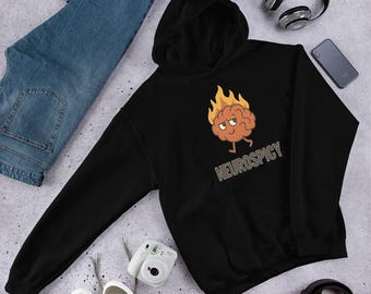 May include: Black hooded sweatshirt with a cartoon brain on fire graphic. The text "NEUROSPICY" is below the graphic. The sweatshirt is on a light gray surface with blue jeans, a camera, headphones, and a phone.