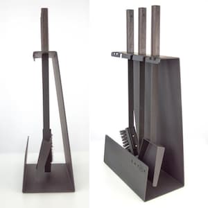Könnte beinhalten: Ein schwarzes Kaminwerkzeug-Set mit Ständer. Das Set enthält einen Schürhaken, eine Schaufel, eine Bürste und eine Zange, alle mit dunklen Holzgriffen. Der Ständer ist aus schwarzem Metall gefertigt und trägt das Wort "SAVEN".