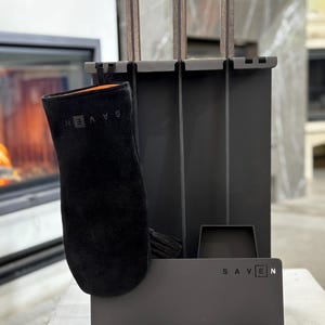 Könnte beinhalten: Ein schwarzes Kaminwerkzeug-Set mit passendem Handschuh. Das Set enthält einen Schürhaken, eine Schaufel und eine Bürste, alle mit dunklen Holzgriffen. Der Markenname "SAVEN" ist auf der Basis und dem Handschuh aufgedruckt.