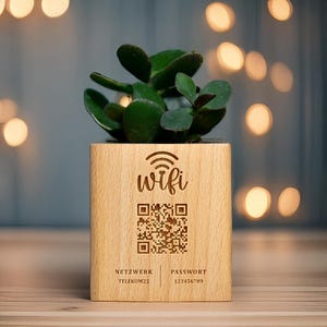 May include: A small, square wooden planter with a live succulent plant. The planter is engraved with the word "wifi", a QR code, and network and password details. The plant has dark green leaves.