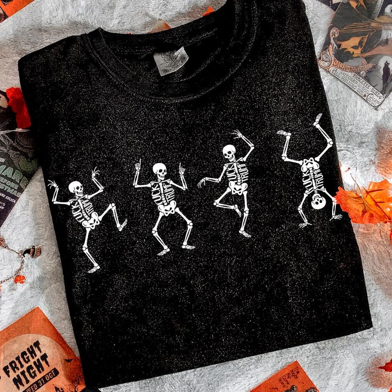 Pu&ograve; includere: T-shirt nero con un disegno di danza di scheletri bianchi. Gli scheletri sono in pose diverse, con gabbie toraciche e teschi dettagliati. La maglietta &egrave; realizzata in materiale morbido, ideale per Halloween o eventi a tema.