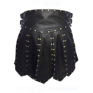Pode incluir: Saia de couro preta com tachas de cor latão e fechos de fivela. A saia tem um design flare e em camadas com costura decorativa e uma cintura larga. Uma peça de roupa elegante para cosplay ou eventos temáticos.