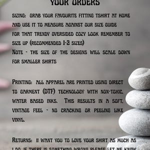 以下が含まれることがあります： ぼやけた背景に「IMPORTANT INFORMATION FOR PLACING YOUR ORDERS」と書かれたテキスト。サイズ、印刷、衣料品の返品の詳細が含まれています。滑らかな灰色の石の積み重ねが右隅にあります。