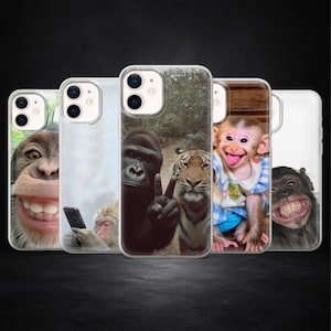 Op de afbeelding: Een verzameling van vijf telefoonhoesjes met humoristische afbeeldingen van primaten en een tijger. De hoesjes tonen verschillende dieren, waaronder een gorilla, een aap en een chimpansee, elk met een unieke uitdrukking. De hoesjes zijn transparant met de dierenafbeeldingen.