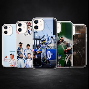 May include: A collection of iPhone cases featuring Formula 1 racing themes. The cases display images of drivers, racing scenes, and celebratory moments. The cases are clear with various designs, including a driver in a racing suit and a champagne celebration.
