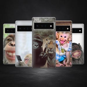 May include: A collection of phone cases featuring images of various primates and a tiger. The cases display a range of expressions, including smiling and posing. The cases are in a row against a dark background.